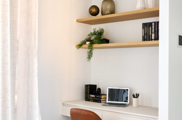 Study nook with floating timber shelves and tan desk chair
