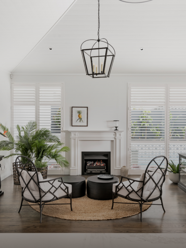 Luxury living area with high ceilings in a high-end Perth home featuring a timeless luxurious fireplace, pendant lighting, and polished jarrah flooring. Part of a custom-built luxury home by Oswald Homes.