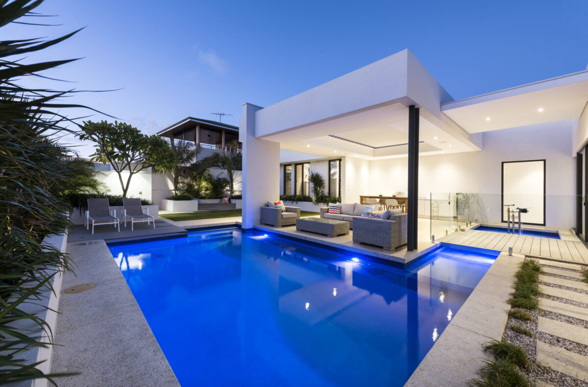 dark blue swimming pool with pavers in the evening