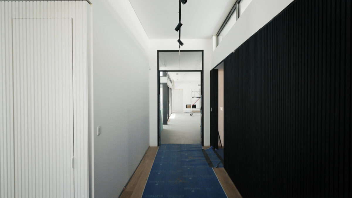 Hallway in an almost finished home showing a protective layer over the wooden flooring