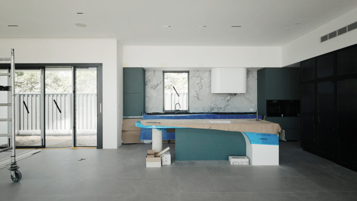 partially finished home build, with dark green kitchen cabinets