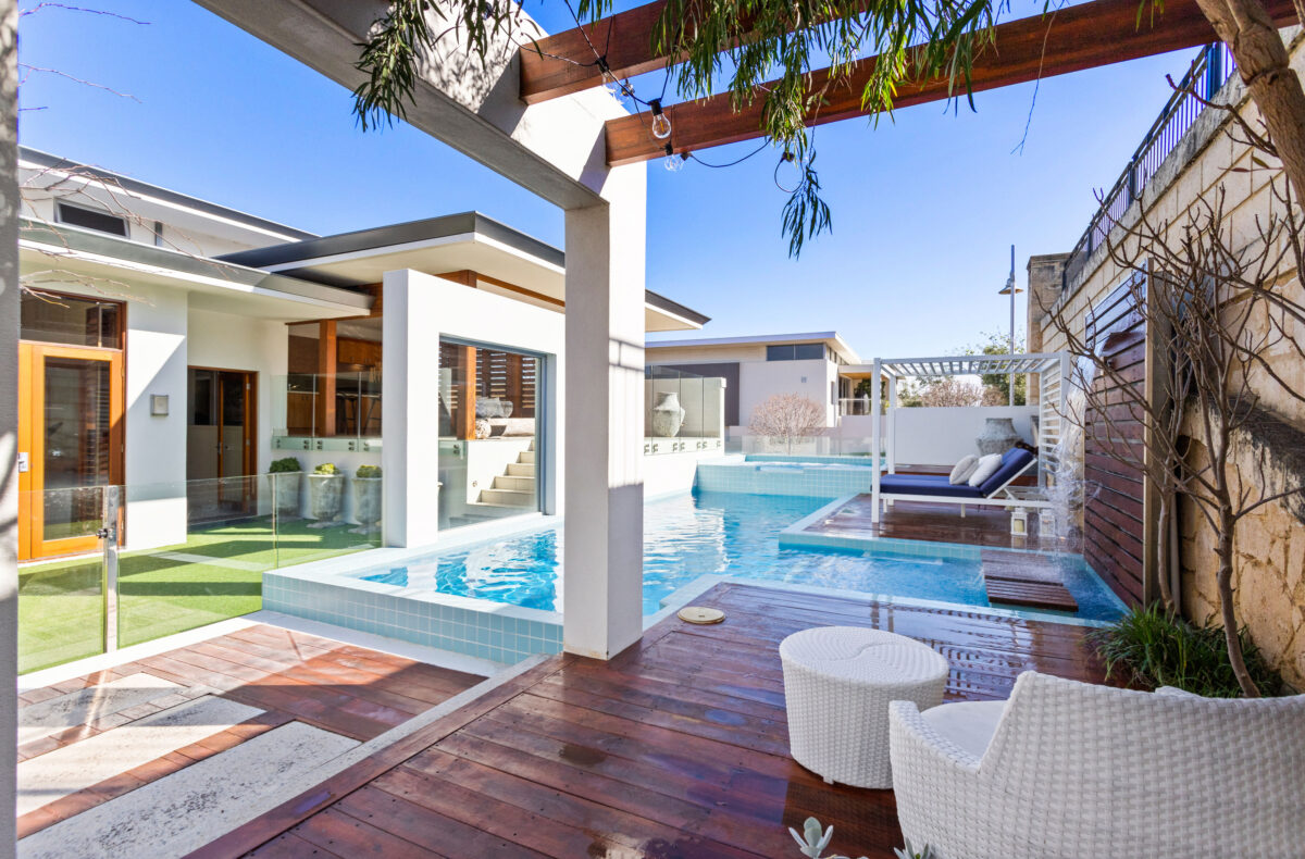 wet, open decking area overlooking swimming pool and sun lounger