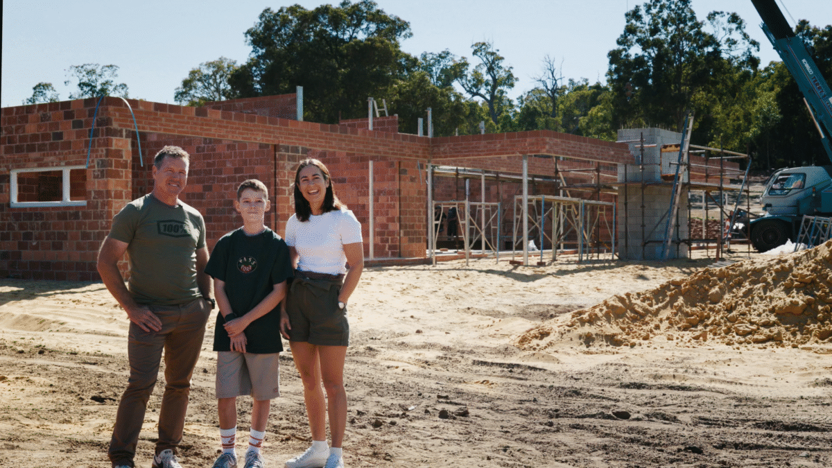 Our lovely clients stand in front of their in-construction luxury home, built by Oswald Homes in Banjup.