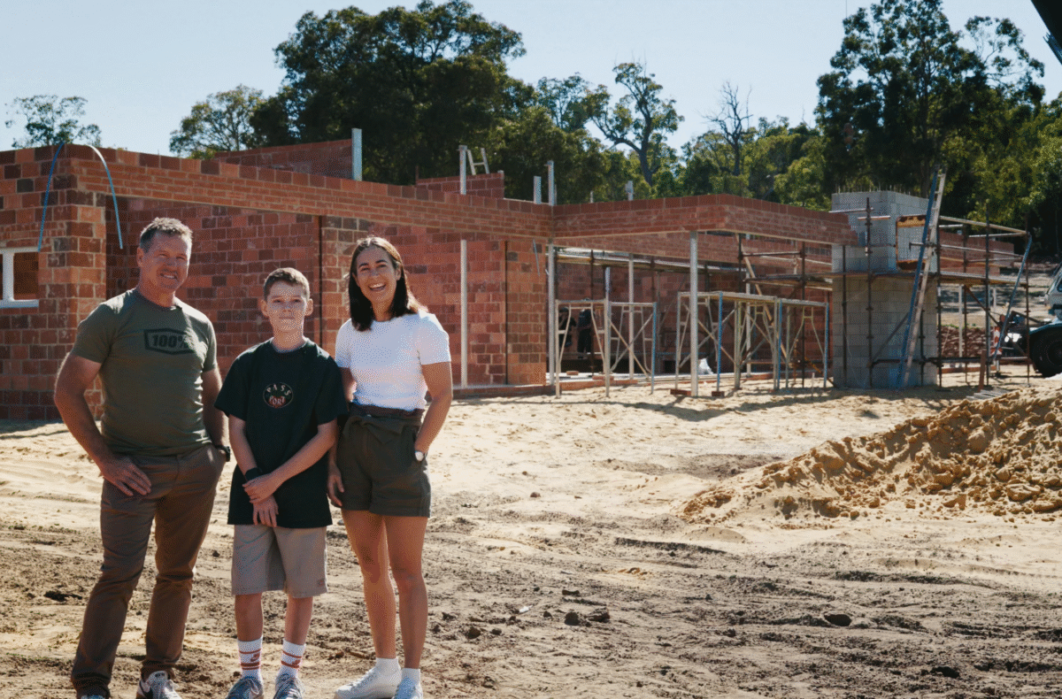 Our lovely clients stand in front of their in-construction luxury home, built by Oswald Homes in Banjup.