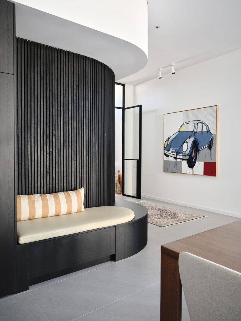 Curved black batten feature wall with built in bench seat