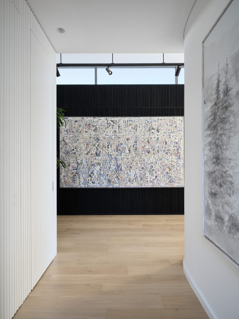 Hallway looking through to artwork on a black feature wall