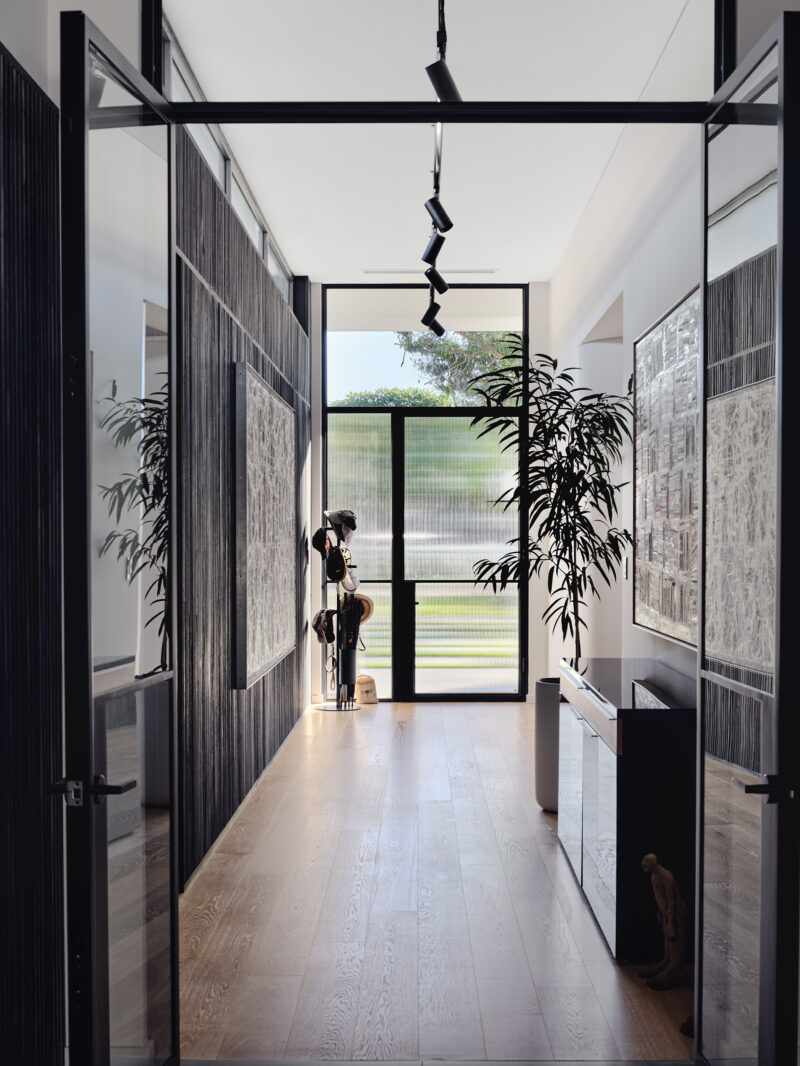 Hallway with black steel framed doors opening to the garden