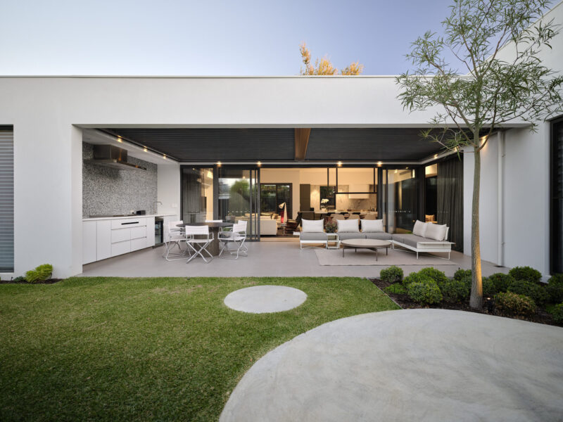 Courtyard with lawn, circular paving and alfresco beyond