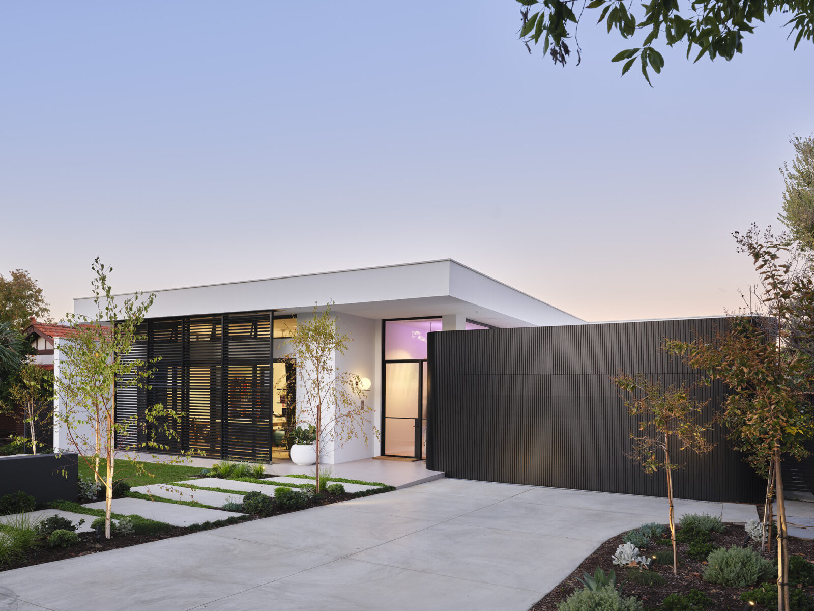 The Gallerie is a luxury custom home design featuring sleek, modern elements like polished plasters, wall cladding, timber detailing, and beautiful natural materials at first glance. Built by barefoot luxury custom home builders, Oswald Homes.