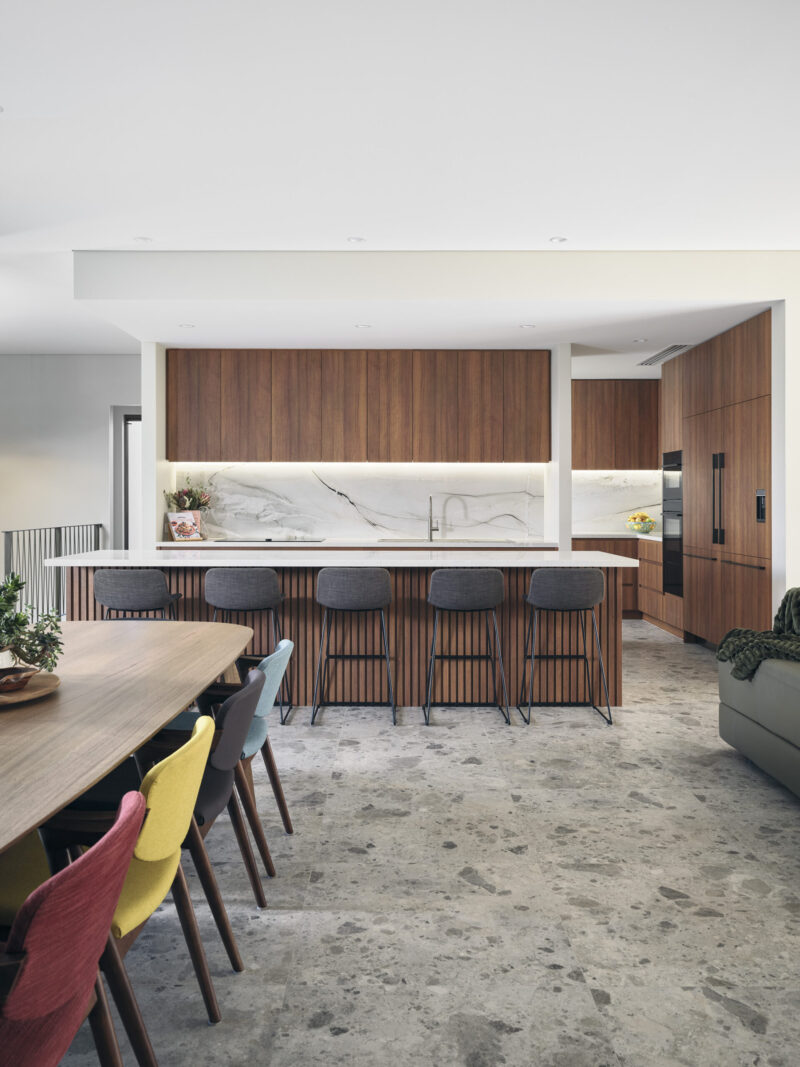 Kitchen and dining with marble island bench and coloured dining chairs
