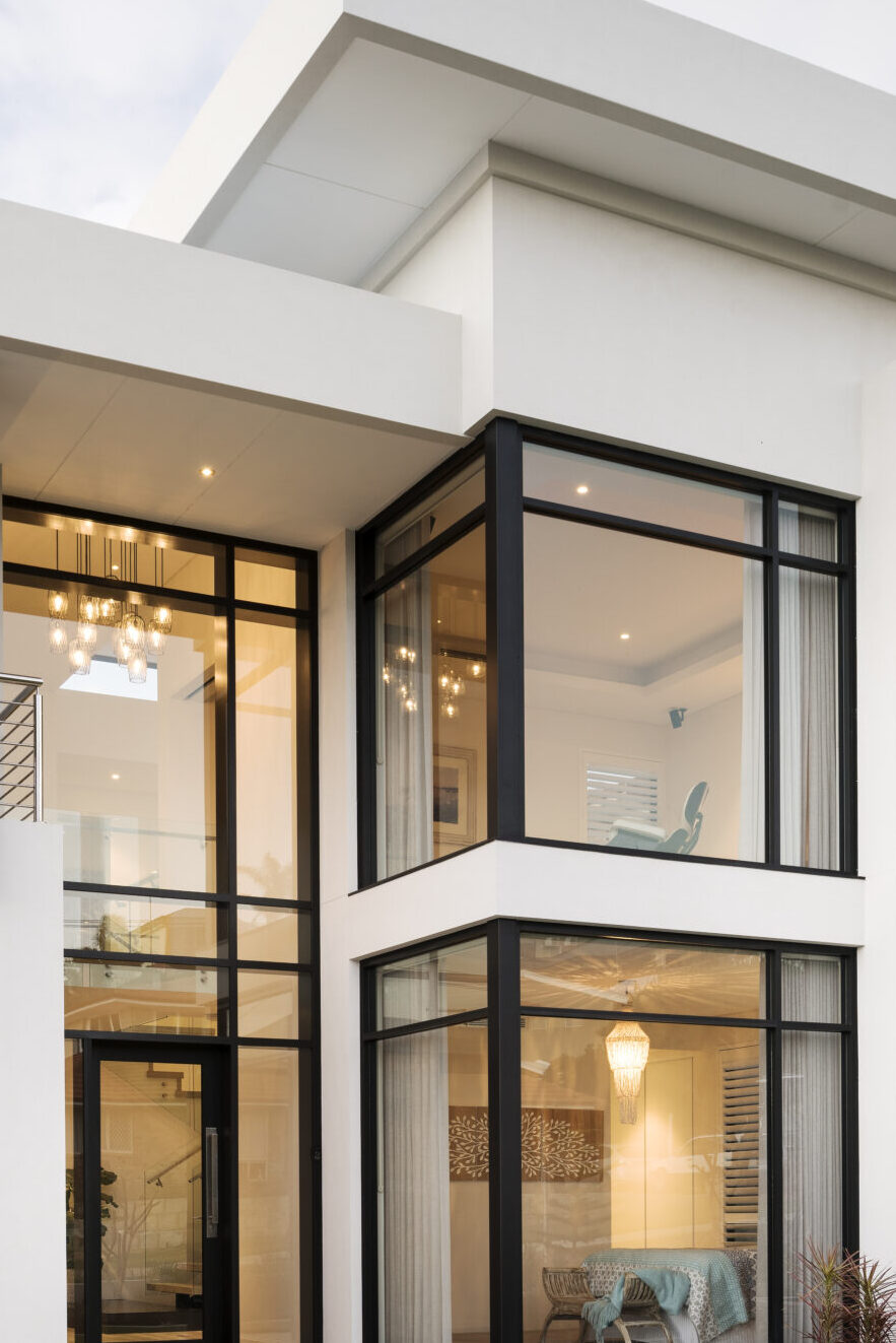 Close up shot of the details of this custom luxury home built by Oswald Homes, featuring glass windows with a dark trim.