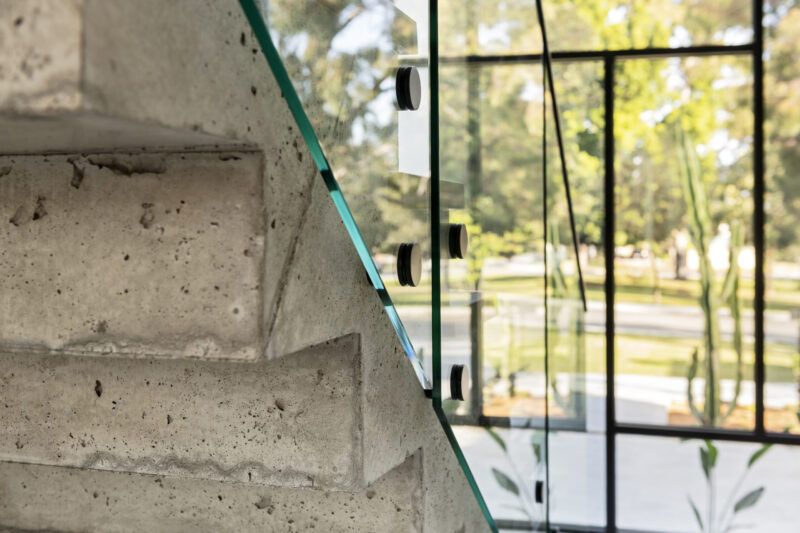 Exposed concrete, floating staircase in The Nelson, by custom luxury homebuilder Oswald Homes.